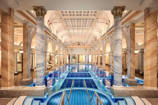 Internal view of a spa area with a luxurious huge pool, made all over with marble in earth tones