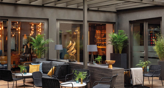 Restaurant with grey tables and chairs, plants and minimal design